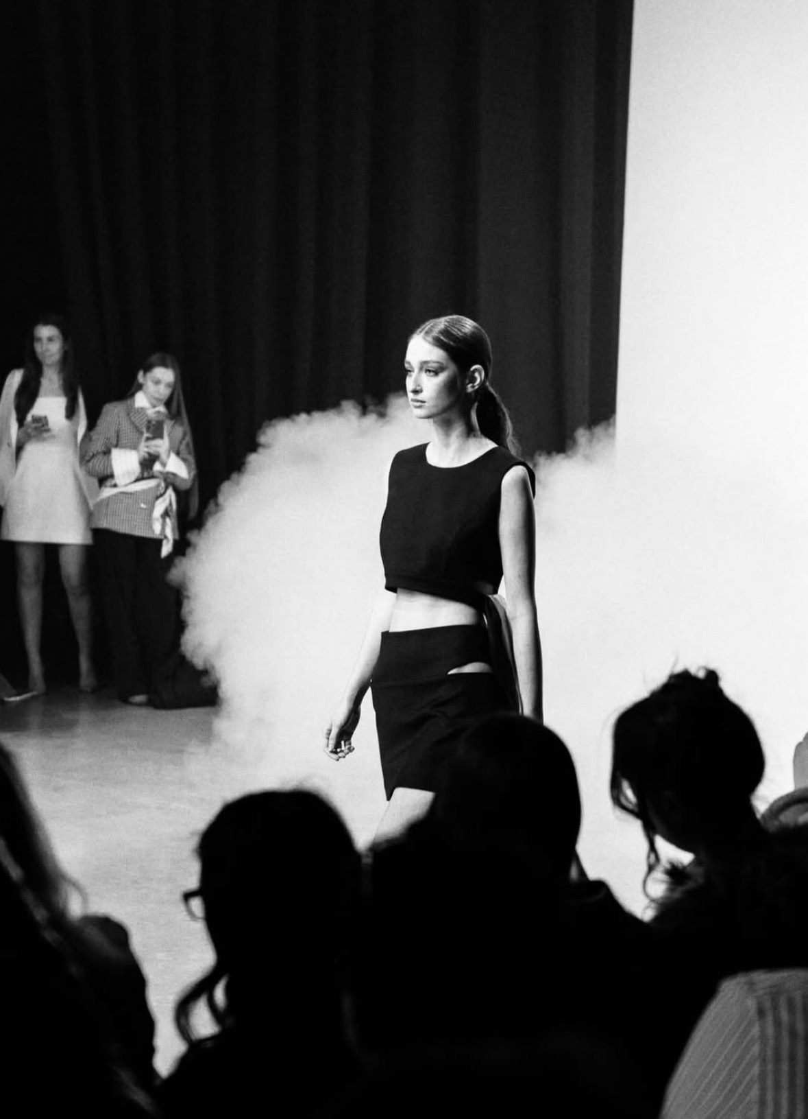 Arina Mura walking the runway in a black two-piece look