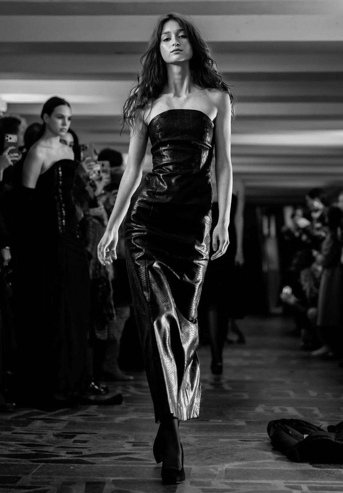 Arina Mura walking the runway in a metallic strapless gown